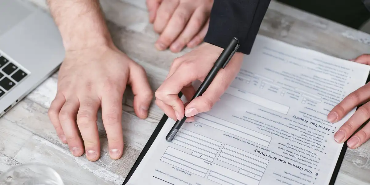 Un conseiller présente un contrat de complémentaire santé à un salarié dans un bureau lumineux.